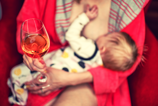 mom breastfeeding with wine